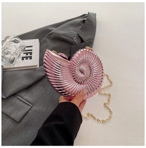 Close-up of pink seashell-shaped acrylic clutch with metallic finish and gold chain