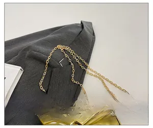 Detail of golden flower-shaped mini bag with metallic petals and fine chain strap