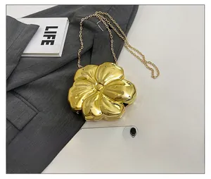 Detailed view of a golden flower acrylic evening clutch bag with a metallic chain strap