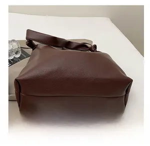 Macro detail of the wide, durable bottom and lychee pattern leather of the coffee tote bag