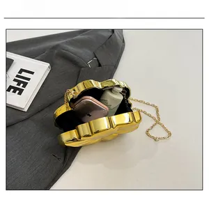 Internal view of gold flower evening clutch bag showing capacity for phone and cosmetics