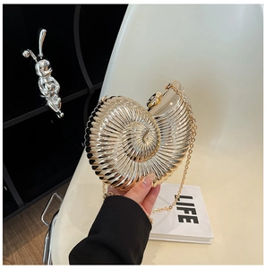 Detailed view of the gold seashell clutch with metallic texture and sleek chain strap