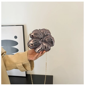 Detailed close-up of a purple floral acrylic clutch bag with a gold chain strap