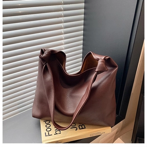 Detail view of large brown lychee texture tote bag with knotted shoulder strap design
