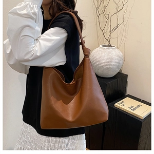 Close-up of caramel leather shoulder bag with unique knotted strap detail and soft texture