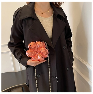 Detail shot of a rose gold 3D flower-shaped clutch bag with shiny metallic finish