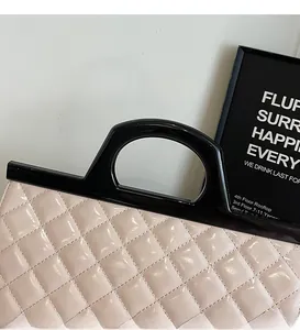 Nahaufnahme der gesteppten Lackledertasche in Rosa mit schwarzem Griff und Herzschloss