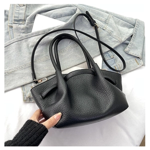 Dettaglio della pelle nera a grana di litchi e hardware dorato sulla borsa a secchiello retro