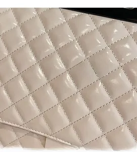 Makro-Detail der beigen gesteppten Ledertextur mit glänzender Oberfläche und Naht