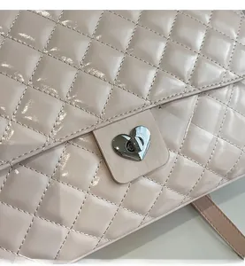 Detail einer glänzenden Stepptasche mit silbernem herzförmigem Metalldrehverschluss