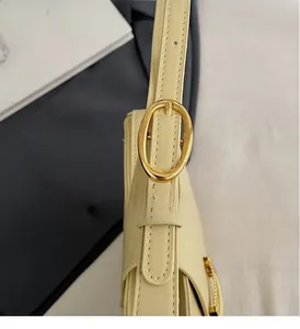 Detail of adjustable shoulder strap with premium golden oval metal buckle on beige bag