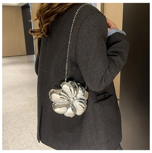 Detail of silver metallic flower evening bag with 3D petals and a delicate chain strap