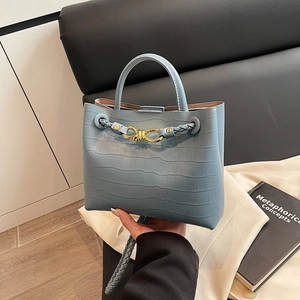 Light blue crocodile embossed handbag with gold knot buckle and woven shoulder strap