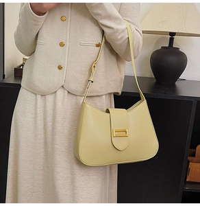 Detail of light beige leather shoulder bag featuring a sleek golden rectangular metal buckle
