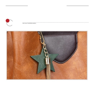 Détail d'un sac à main en cuir vintage avec breloque étoile verte et franges métalliques