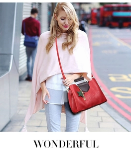 Détail d'un sac cabas rouge en similicuir avec texture litchi et gland étoile