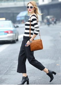 Sac bandoulière en cuir marron porté avec un haut rayé pour un style urbain chic