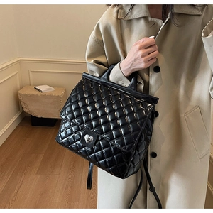 Detail der schwarzen gesteppten Tasche mit silbernem herzförmigem Metalldrehverschluss