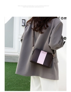 Detalle del bolso bandolera bicolor marrón y rosa con herrajes dorados en modelo