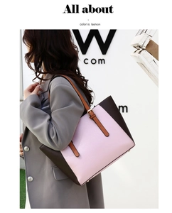 Detalle del bolso tote bicolor rosa y marrón con correa ajustable y tacos metálicos en base