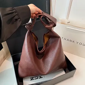 Large dark brown soft leather tote bag with knot handle detail in a stylish gift box