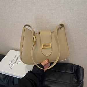 Elegant beige half-moon shoulder bag with a gold metal buckle in a minimalist design