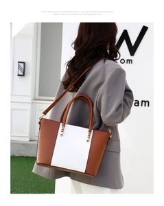 Photo en extérieur d'une femme portant un sac cabas vintage bicolore marron et blanc à l'épaule