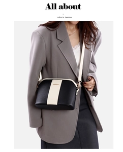 Détail d'un sac bandoulière noir et beige avec bandoulière réglable sur un modèle