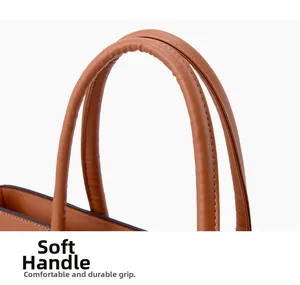 Détail de la poignée en cuir marron caramel avec couture premium sur un grand sac cabas