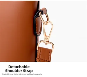 Détail d'un sac cabas marron montrant le fermoir doré et la bandoulière amovible solide