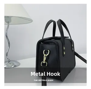 Detail of premium golden metal hook and adjustable strap on black crossbody bag