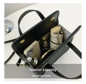 Top view of structured black crossbody bag showing internal capacity for daily essentials