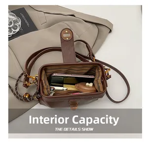 Detail showing the internal capacity of the brown vintage crossbody bag with striped lining