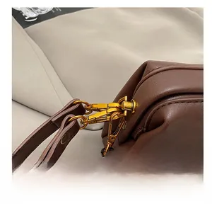 Detail shot of premium dark brown leather bag with high-quality golden metal clasp