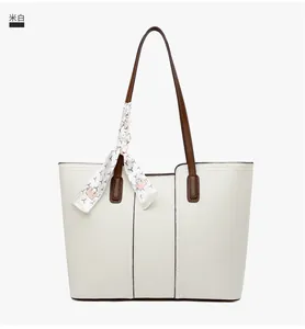 Détail du sac fourre-tout blanc crème avec texture litchi et poignée en foulard de soie