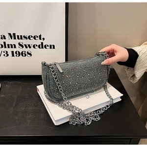 Detail of rhinestone-studded denim bag showing metallic chain strap and texture