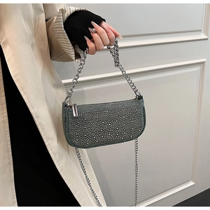 Detail of blue rhinestone encrusted handbag with dual silver metal chains shown by model