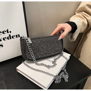 Close-up of black denim bag with sparkling rhinestones and chunky silver chain