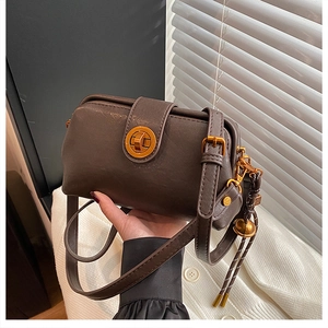 Detailed macro view of vintage brown leather handbag with elegant gold rotating lock