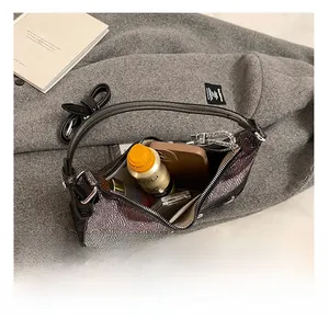Interior view of crescent shoulder bag showing capacity for phone and cosmetics