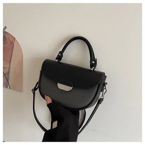 Detail of grey woven saddle bag with black leather flap and silver oval buckle closure