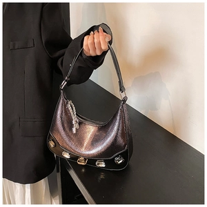 Detail of purple faux snakeskin crescent bag with five large rectangular rhinestones on base