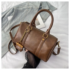 Top view of a vintage dark brown Boston bag with metal padlock detail on white fabric