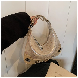 Detail of shimmering snake scale texture crescent bag with crystals and gold logo