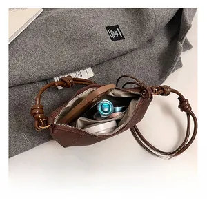 Internal view of dark brown leather dumpling bag showing capacity for phone and cosmetics