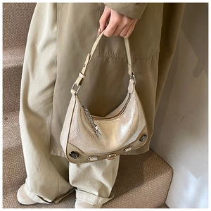 Detail of metallic snakeskin crescent hobo bag featuring decorative gems and a fixed handle