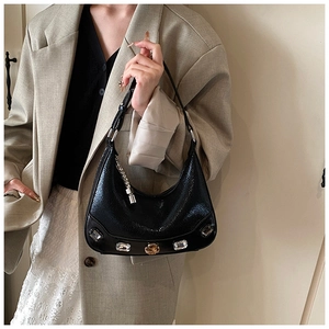Detail of black faux snake leather crescent bag with large crystal embellishments