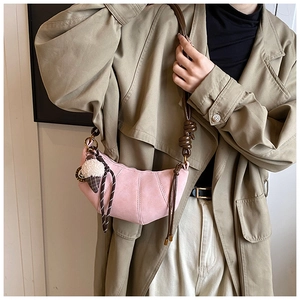Detail of pink hobo bag with knotted brown strap and plush ice cream charm accessory