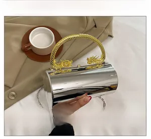 Detailed view of silver mirror acrylic bag with ornate gold dragon-shaped handle and chain