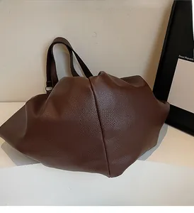 Detail of brown pebbled leather tote bag showing large capacity and soft texture